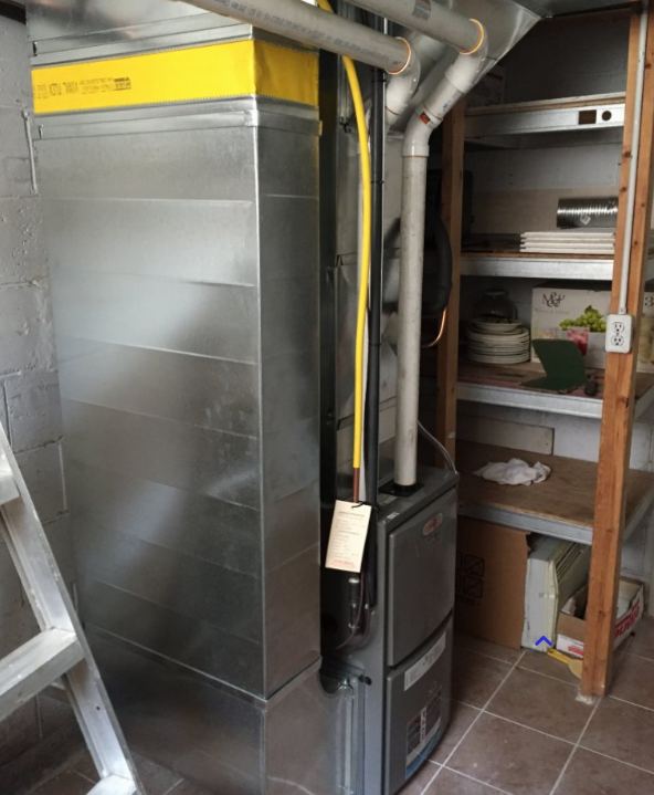 A furnace in a utility closet with new ductwork